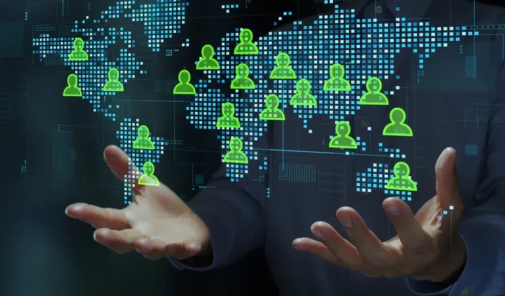 Businessperson holding world map and people icons.